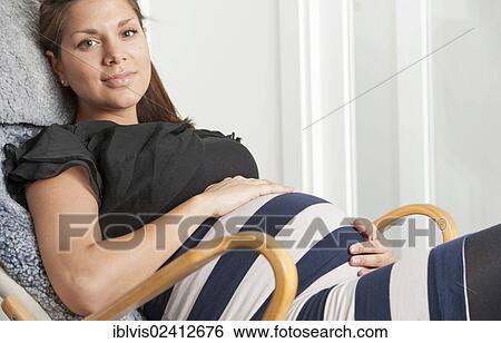 Pregnant woman holding hands on her stomach View Large Photo Image Stock Photograph - Pregnant woman holding hands on her stomach. Fotosearch