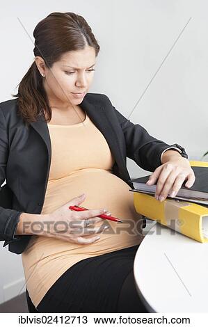 Pregnant woman sitting in an office looking troubled View Large Photo Image Stock Image - Pregnant woman sitting in an office looking troubled. Fotosearch