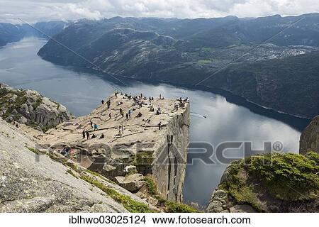 Picture - "Preikestolen or Prekestolen, Preacher's Pulpit or Pulpit Rock with tourists, views across the fjord landscape, Preikestolen, Lysefjord, Rogaland, Western Norway, Norway, Europe". Fotosearch