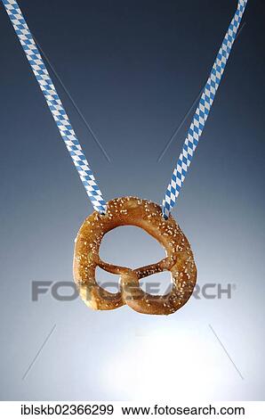 Stock Photo - Pretzel hanging on a white and blue ribbon. Fotosearch