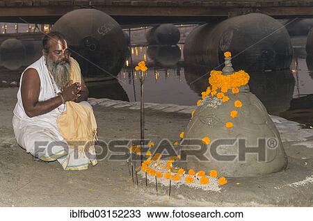 "Priest praying at a shiva idol made of sand at the Sangam, the confluence of the rivers Ganges, Yamuna and Saraswati, during Kumbha Mela, Allahabad, Uttar Pradesh, India, Asia" View Large Photo Image Stock Image - "Priest praying at a shiva idol made of sand at the Sangam, the confluence of the rivers Ganges, Yamuna and Saraswati, during Kumbha Mela, Allahabad, Uttar Pradesh, India, Asia". Fotosearch