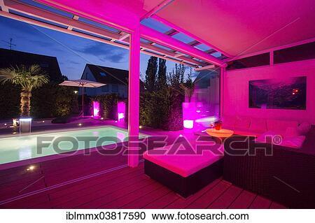 Stock Image - "Private house at night with light show, conservatory, lounge, pool and terrace, Germany, Europe". Fotosearch