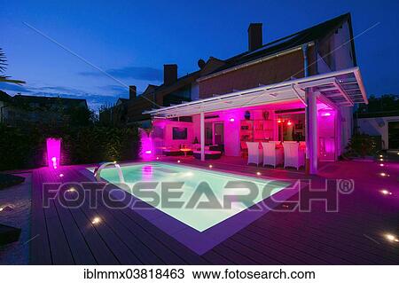 "Private terraced house with a conservatory, a pool and a terrace with display lighting at night, Germany, Europe" View Large Photo Image Stock Image - "Private terraced house with a conservatory, a pool and a terrace with display lighting at night, Germany, Europe". Fotosearch