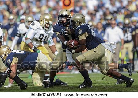 Stock Image - "QB Trey Miller, #1 Navy, hands off the ball to FB Chris Swain, #37 Navy, during the NCAA football game between the Navy and the Notre Dame on September 1, 2012 in Dublin, Ireland, Europe". Fotosearch