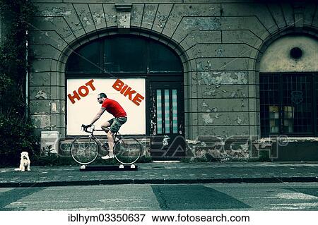 "Racing cyclist travelling on free motion cycling rollers in front of a rundown house with an empty shop, dog sitting next to him, Germany, Europe" View Large Photo Image Stock Photo - "Racing cyclist travelling on free motion cycling rollers in front of a rundown house with an empty shop, dog sitting next to him, Germany, Europe". Fotosearch