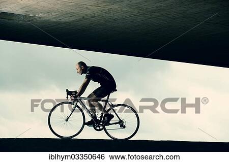 Racing cyclist travelling under a bridge View Large Photo Image Stock Photograph - Racing cyclist travelling under a bridge. Fotosearch