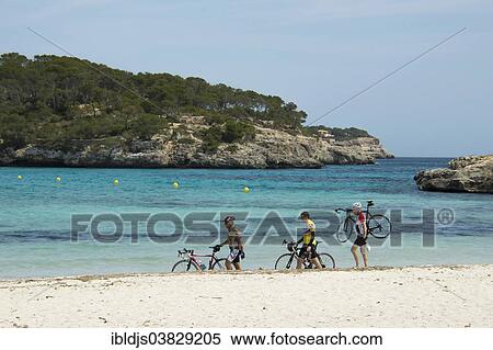 "Racing cyclists walking along the beach, Cala Mondrago, Santanyi, Majorca, Balearic Islands, Spain, Europe" View Large Photo Image Stock Photography - "Racing cyclists walking along the beach, Cala Mondrago, Santanyi, Majorca, Balearic Islands, Spain, Europe". Fotosearch
