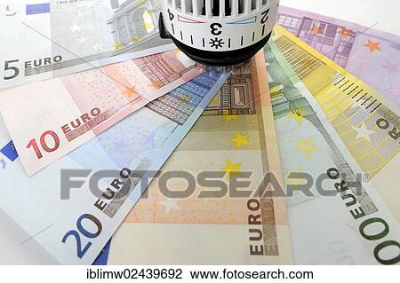 Stock Image - "Radiator valve with euro banknotes, symbolic image for heating costs, energy costs". Fotosearch