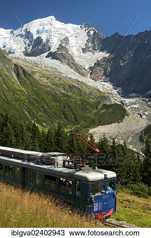 Stock Image - "Railcar of the Tramway du Mont-Blanc in front of the Aiguille de Bionnassay summit, Mont Blanc region, Haute-Savoie, France, Europe". Fotosearch