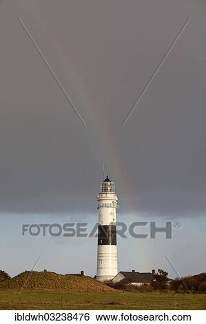 Stock Photograph - "Rainbow over the Kampen lighthouse, also Red Cliff lighthouse, Kampen, Sylt, North Frisian Islands, Schleswig-Holstein, Germany, Europe". Fotosearch