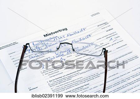 Stock Photo - Reading glasses lying on a German rental contract. Fotosearch