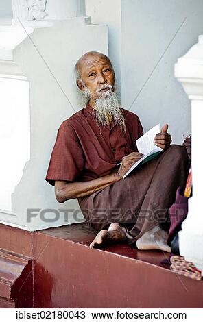 "Reading monk sitting between the pillars of the Shwedagon Pagoda in Yangon, Myanmar, Burma, Southeast Asia, Asia" View Large Photo Image Stock Image - "Reading monk sitting between the pillars of the Shwedagon Pagoda in Yangon, Myanmar, Burma, Southeast Asia, Asia". Fotosearch