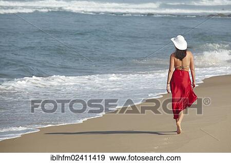 "Rear view of a young woman wearing a bikini and a red sarong walking along a beach in summer, Arcachon, Aquitaine, France, Europe" View Large Photo Image Stock Photo - "Rear view of a young woman wearing a bikini and a red sarong walking along a beach in summer, Arcachon, Aquitaine, France, Europe". Fotosearch