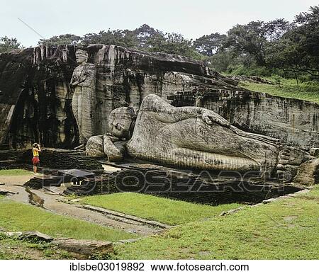 Stock Image - "Reclining Buddha, entrance to Nirvana, a tourist standing in front of the Gal Vihara rock temple, UNESCO World Heritage Site, Polonnaruwa, Nordliche Zentralprovinz, Sri Lanka, Asia". Fotosearch
