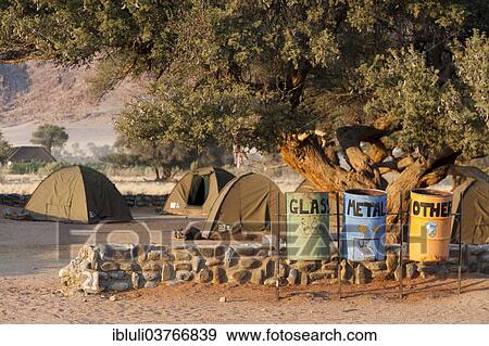 Stock Photo - "Recycling bins for glass, metal and other materials and tents, Sesriem Campsite, Khomas Region, Namibia, Africa". Fotosearch