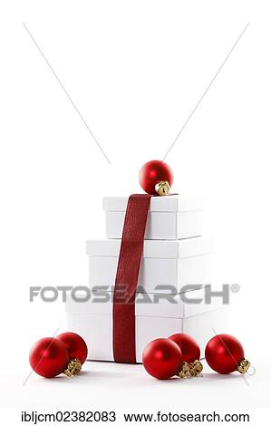 Stock Image - Red Christmas baubles and presents with a red ribbon. Fotosearch