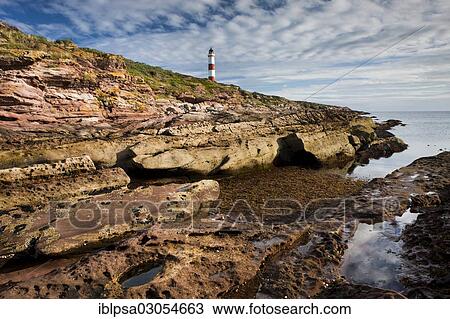 Stock Image - "Red cliffs and lighthouse, Tarbat Ness, Scotland, United Kingdom, Europe". Fotosearch