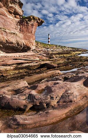 Stock Photography - "Red cliffs and lighthouse, Tarbat Ness, Scotland, United Kingdom, Europe". Fotosearch