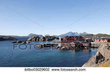 Stock Image - "Red fishermen's houses, called rorbuer, holiday resort in Mortsund with aquaculture fish farming, Mortsund, Lofoten, Nordland, Norway, Europe". Fotosearch