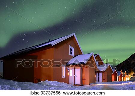 Stock Photograph - "Red fishing huts in winter with Northern Lights, Sommeroya, Tromso, â€ªTroms, Northern Norway, Norway, Europe". Fotosearch