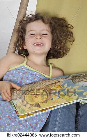 Stock Photography - "Red-haired girl, 5 years old, holding a children's book". Fotosearch