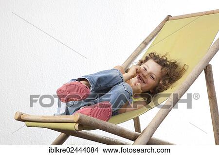 Picture - "Red-haired girl, 5 years old, sitting on a deck chair". Fotosearch