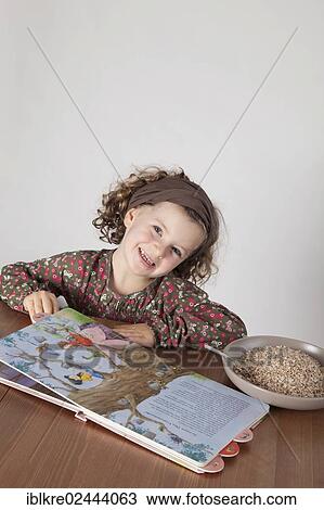 "Red-haired girl, 5 years old, sitting at the table with a children's book" View Large Photo Image Stock Image - "Red-haired girl, 5 years old, sitting at the table with a children's book". Fotosearch