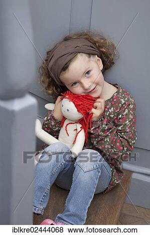 "Red-haired girl, 5 years old, sitting on a staircase with a doll" View Large Photo Image Stock Photo - "Red-haired girl, 5 years old, sitting on a staircase with a doll". Fotosearch