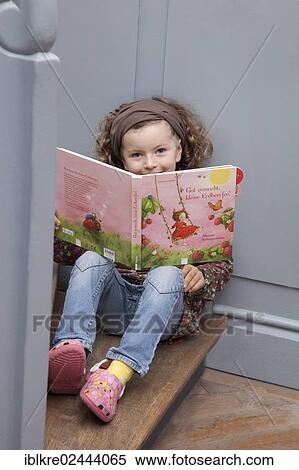 "Red-haired girl, 5 years old, sitting on a staircase with a children's book" View Large Photo Image Stock Photography - "Red-haired girl, 5 years old, sitting on a staircase with a children's book". Fotosearch