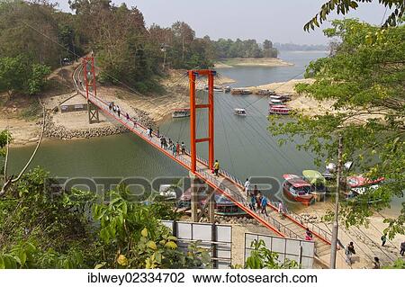 Stock Image - "Red suspension bridge, Jhulonto Bridge in Rangamati, Kaptai Lake, Chittagong Hill Tracts, Bangladesh, South Asia, Asia". Fotosearch