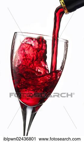 Stock Image - Red wine being poured into a glass. Fotosearch