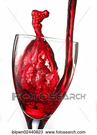 Stock Image - Red wine being poured into a glass. Fotosearch