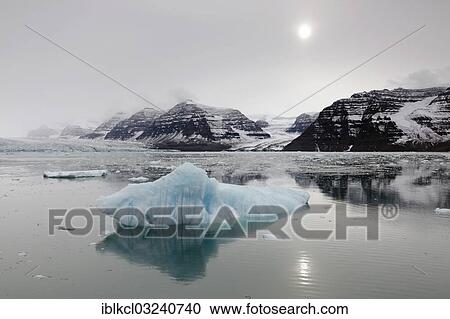 "Reflection of icebergs, mountain scenery and the sun on an overcast day, Vikingebugt, Scoresbysund, Sermersooq, Greenland, North America" View Large Photo Image Stock Image - "Reflection of icebergs, mountain scenery and the sun on an overcast day, Vikingebugt, Scoresbysund, Sermersooq, Greenland, North America". Fotosearch