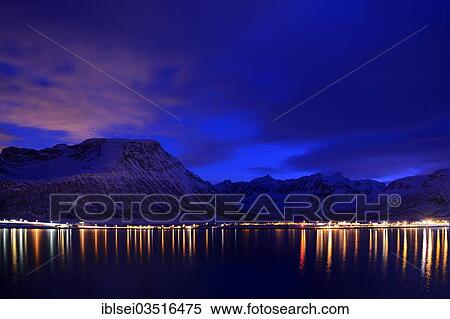 Stock Photography - "Reflection of lights in the fjord with mountains the blue hour, Grotfjord, Tromso, â€ªTroms, Northern Norway, Norway, Europe". Fotosearch