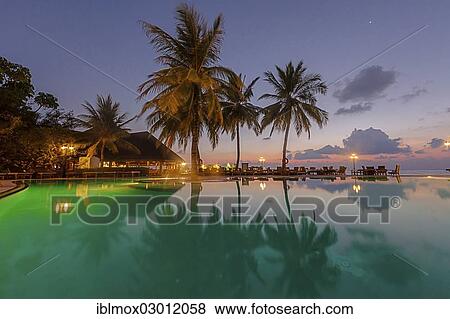 Stock Photo - "Restaurant and pool area of Paradise Island at dusk, Indian Ocean, Lankanfinolhu, North Male Atoll, Maldives, Asia". Fotosearch