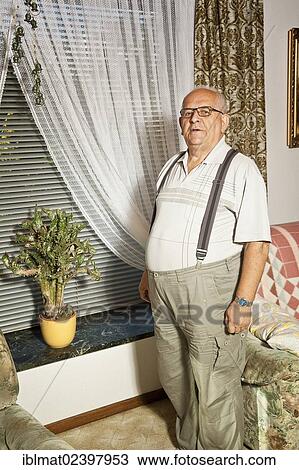 Retired man standing in front of a cactus on a window sill View Large Photo Image Stock Image - Retired man standing in front of a cactus on a window sill. Fotosearch