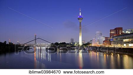 Stock Image - "Rhine tower, Gehry Buildings, Neuer Zollhof, media harbor, dusk, blue hour, Dusseldorf, North Rhine-Westphalia, Germany, Europe". Fotosearch