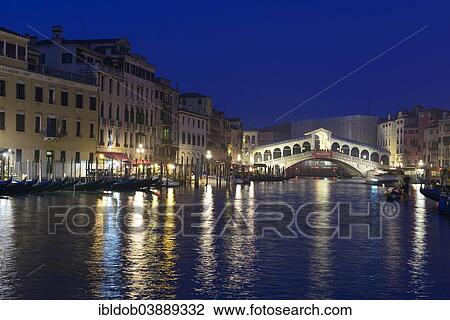 Stock Image - "Rialto Bridge, Ponte di Rialto, on the Grand Canal at night, Venice, Veneto, Italy, Europe". Fotosearch