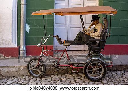 "Rickshaw driver waiting for customers and reading a book, Trinidad, Sancti Spiritus Province, Cuba, North America" View Large Photo Image Stock Photo - "Rickshaw driver waiting for customers and reading a book, Trinidad, Sancti Spiritus Province, Cuba, North America". Fotosearch