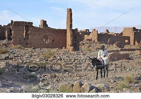 "Rider on a donkey in front of dilapidated mud houses, Tamnougalt Kasbah, Draatal, Tamnougalt, Souss-Massa-Draa region, Morocco, Africa" View Large Photo Image Stock Photograph - "Rider on a donkey in front of dilapidated mud houses, Tamnougalt Kasbah, Draatal, Tamnougalt, Souss-Massa-Draa region, Morocco, Africa". Fotosearch