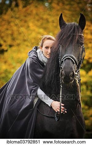 "Rider with cape on a Frisian, black horse, gelding" View Large Photo Image Stock Image - "Rider with cape on a Frisian, black horse, gelding". Fotosearch