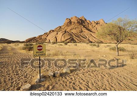 Stock Image - Road Closed sign, savannah landscape with granite rocks of the Pontok Mountains, Spitzkoppe, Grosse Spitzkuppe Nature Reserve, Namibia, Africa. Fotosearch