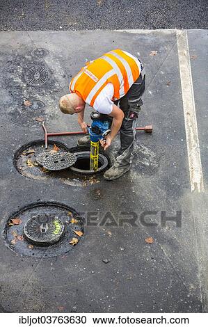 Stock Image - "Road construction worker connecting a hydrant for water supply of the construction site, Essen, North Rhine-Westphalia, Germany, Europe". Fotosearch