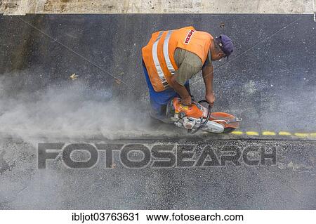 "Road construction worker operating a disc cutter, tarmac laying works at a road construction site, Essen, North Rhine-Westphalia, Germany, Europe" View Large Photo Image Stock Image - "Road construction worker operating a disc cutter, tarmac laying works at a road construction site, Essen, North Rhine-Westphalia, Germany, Europe". Fotosearch