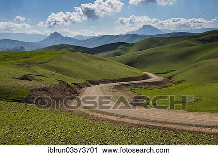 Stock Image - "Road sneaking through the green hilly landscape, on the border of Iran, Darbandikhan, Iraqi Kurdistan, Iraq, Asia". Fotosearch