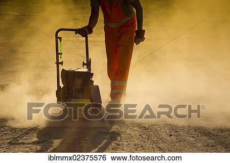 "Road worker operating a plate vibrator to compress a dusty road, Hesse, Germany, Europe, PublicGround, Europe" View Large Photo Image Stock Photograph - "Road worker operating a plate vibrator to compress a dusty road, Hesse, Germany, Europe, PublicGround, Europe". Fotosearch