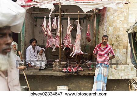 "Roadside slaughterhouse, skinned animals hanging from beams, raw meat underneath, butcher waiting for customers, Dhaka, Bangladesh, South Asia, Asia" View Large Photo Image Stock Photo - "Roadside slaughterhouse, skinned animals hanging from beams, raw meat underneath, butcher waiting for customers, Dhaka, Bangladesh, South Asia, Asia". Fotosearch