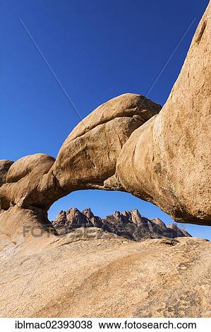 "Rock arch, Pontok Mountains at the back, near the Spitzkoppe granite peaks, Damaraland, Namibia, Africa" View Large Photo Image Stock Photo - "Rock arch, Pontok Mountains at the back, near the Spitzkoppe granite peaks, Damaraland, Namibia, Africa". Fotosearch