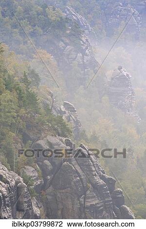 Stock Image - "Rocks in fog in autumn, Elbe Sandstone Mountains, Saxon Switzerland, Bad Schandau, Saxony, Germany, Europe". Fotosearch