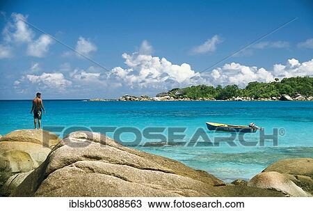 "Rocky beach with a local fisherman and a fishing boat, Anse Lazio, Praslin, Seychelles, Africa" View Large Photo Image Stock Image - "Rocky beach with a local fisherman and a fishing boat, Anse Lazio, Praslin, Seychelles, Africa". Fotosearch